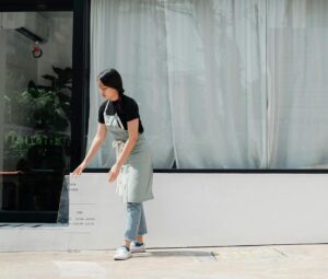 Small business owner setting out store hours sign